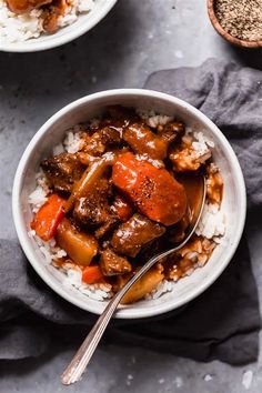 two bowls filled with meat and rice on top of a table next to spoons