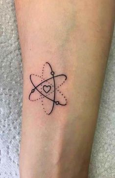 a small black and white tattoo on the leg of a person with a heart in it