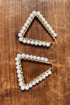 two pieces of jewelry sitting on top of a wooden table