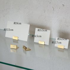 three pieces of metal are on display with price tags