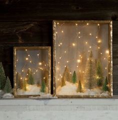 three framed pictures with christmas trees and lights in the snow, on top of a mantle