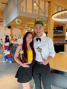 two people standing next to each other in front of a table with decorations on it