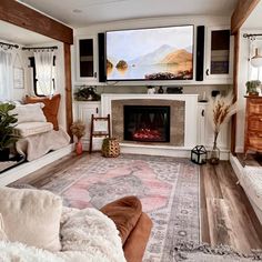 a living room filled with furniture and a flat screen tv mounted to the wall above a fire place