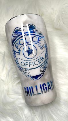 a police officer coffee cup sitting on top of a white blanket