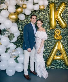 a man and woman kissing in front of balloons