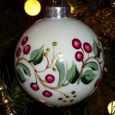 a white ornament with red berries and green leaves