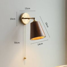 a wall light with a brown shade on it's side and measurements for the length