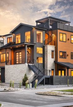 a large house with many windows and steps leading up to the second floor, in front of a cloudy sky