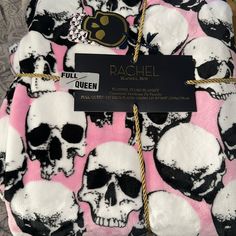 a pink and black blanket with skulls on it