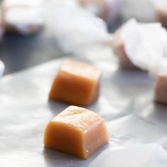 three pieces of caramel sitting on wax paper