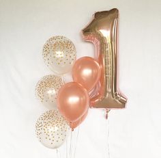 a number one balloon and some balloons in front of it on a white background with gold polka dots