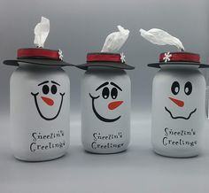 three glass jars with faces painted on them