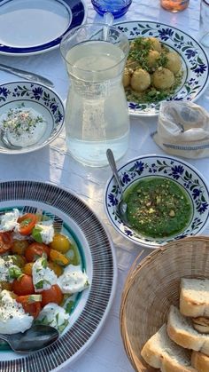 a table topped with plates and bowls filled with food