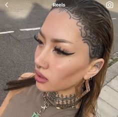 a woman with tattoos on her head is making a face and looking at the camera