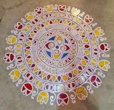 an intricately designed plate on the ground with hearts and flowers painted on it's surface