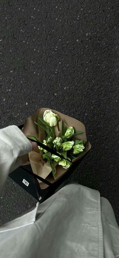 a person holding a bouquet of flowers on the ground