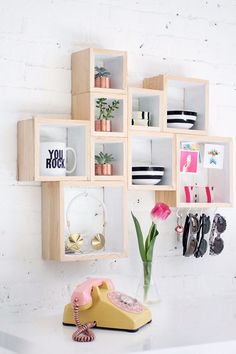 a phone is sitting on a shelf next to a vase with tulips in it