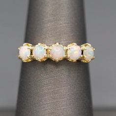 Handcrafted Opal Half Hoop Band Ring in 14k Yellow Gold This prettiest of bands was inspired by a damaged Victorian half hoop ring we stumbled on.  Here we've crafted a new version with fiery opals across the top.  The stones measure about 3.75mm on average and are nestled under six claw prongs each.  At the top the band measures 5.20mm.  It narrows to 2.14mm at the bottom of the shank.  Because of its straight profile, this band would also be suitable for a unique stack!  The ring is crafted in Fine Jewelry Hoop Rings With Diamond Cut, 14k Gold Hoop Rings With Vvs Clarity, Puzzle Ring, Claw Prong, White Band, Diamond Rings Bands, Diamond Hoop Earrings, Marquise Diamond, New Version