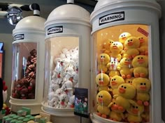 there are many stuffed animals in this display case, and they look like rubber ducks