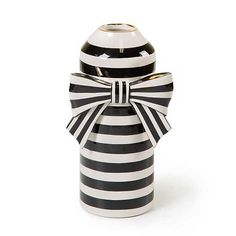 a black and white striped vase with a bow on the front, sitting against a white background