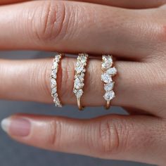 a woman's hand with three different rings on her finger and the other ring is gold