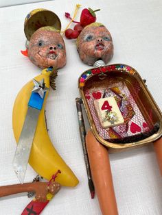 some toys are sitting on a table with scissors and other items around them, including an object that appears to have been made out of clay