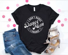 As a Dance Mom, I Don't Dance I Finance. This Funny Dance Mom shirt is made with a soft cotton and a quality print that will have you fall in love with it over and over again. This Premium crafted t-shirt features a crew neck, short sleeve and designed for a super soft and comfortable feel with a high quality cotton Blend. Our t-shirts are made from 3.7 ounce cotton. All solid colors are 100% Airlume combed and ring-spun cotton and all heathered colors are 52% combed ring-spun cotton, 48% polyes Black Graphic Print T-shirt For Dance, Cotton T-shirt With Custom Print For Dance Class, Casual Text Print T-shirt For Dance Class, Dance Mama Shirt, Dance Cotton T-shirt With Custom Print, Dance Mom Shirt, Funny Dance, Dance Mom Shirts, Mom Tshirt