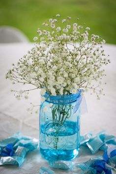 a blue mason jar filled with baby's breath flowers on top of a table