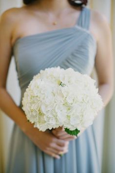 a bridesmaid holding a bouquet of white flowers