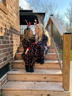 two women are sitting on the steps kissing