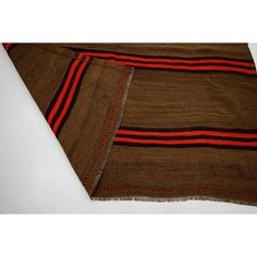 a brown and red striped blanket laying on top of a white table