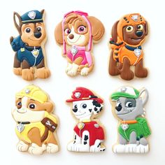 six decorated cookies in the shape of puppies and firemen, including a dog