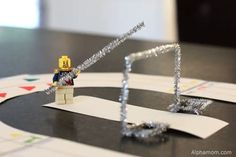 a lego man is playing a game of monopoly on a table with silver tinsel