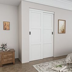 a bedroom with white walls and carpeted flooring, two doors open to reveal another room