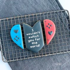 two heart shaped cookies sitting on top of a wire rack with words written on them