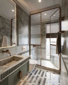 a bathroom with marble walls and flooring next to a walk - in shower stall