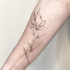 a woman's arm with a flower tattoo on the left side of her arm