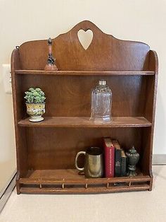 an old wooden shelf with books and cups on it