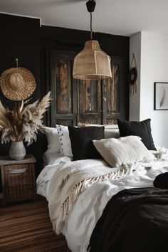 a bedroom with black walls and white bedding, wicker baskets hanging from the ceiling