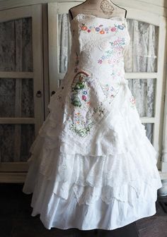 a white wedding dress on display in front of a cabinet