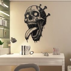 a living room with a desk, chair and large wall decal that has a skull on it