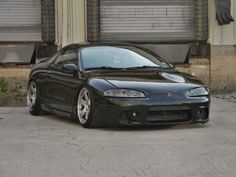 a black sports car parked in front of a building