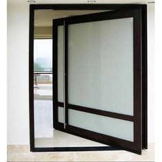 an open door with glass panels on the outside and inside, in front of a white wall