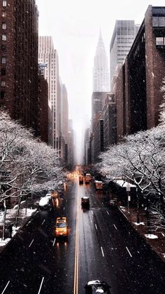 the city street is covered in snow as cars drive down it's side - by - side