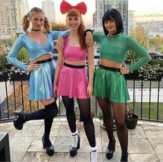 three young women dressed in costumes posing for the camera