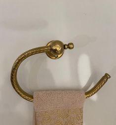 a gold colored towel holder on a white wall