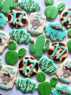 decorated cookies are arranged in the shape of cactuses and other desert related items on a table