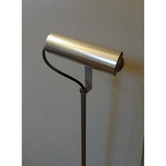 a lamp that is on top of a metal pole with a cord attached to it