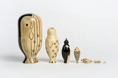 three wooden figurines sitting next to each other on a white surface with one black and the other gold