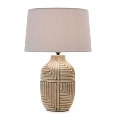 a table lamp with a white shade on it and a beige fabric lampshade